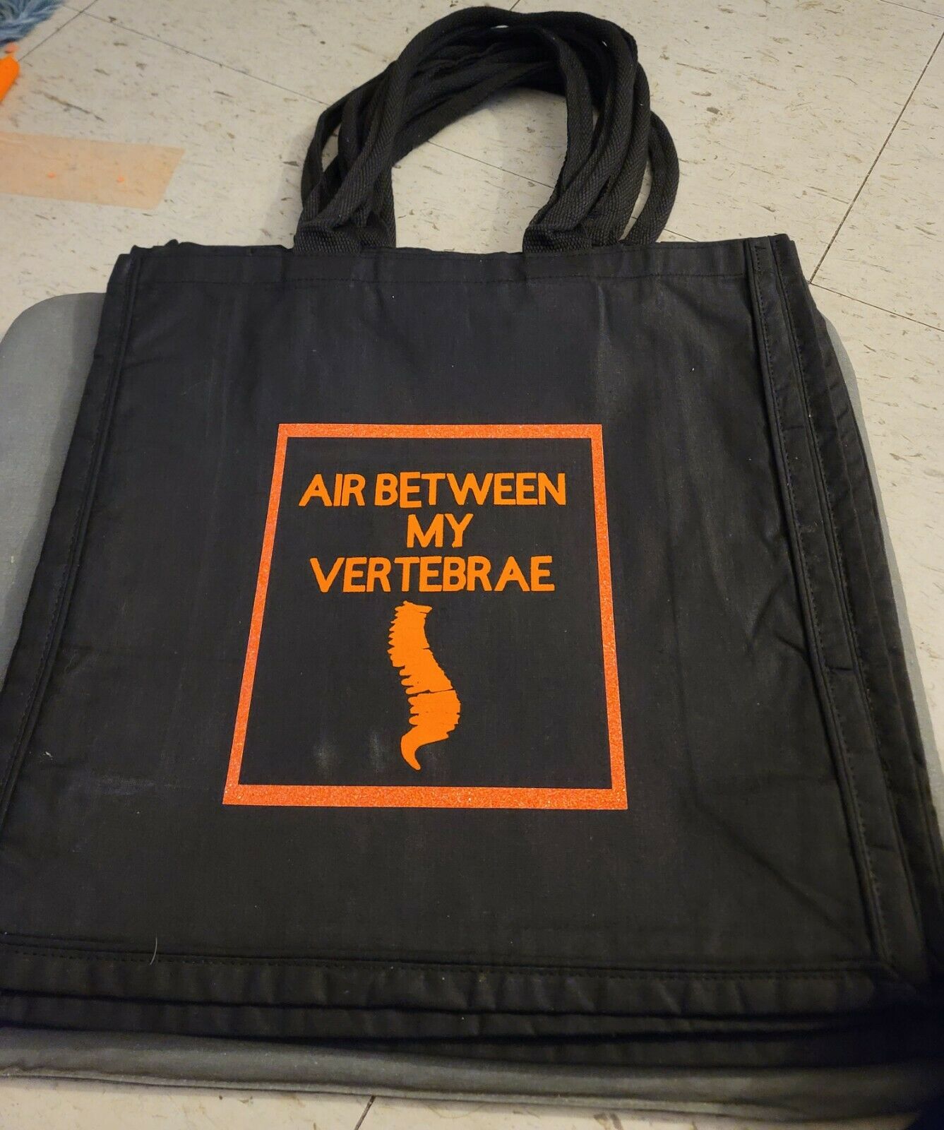 A photo of the AIR BETWEEN MY VERTEBRAE tote bag